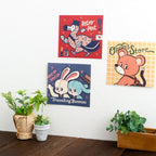 Three artworks from the ob1toy Mini Wall Calendar 2027 pinned to a wall