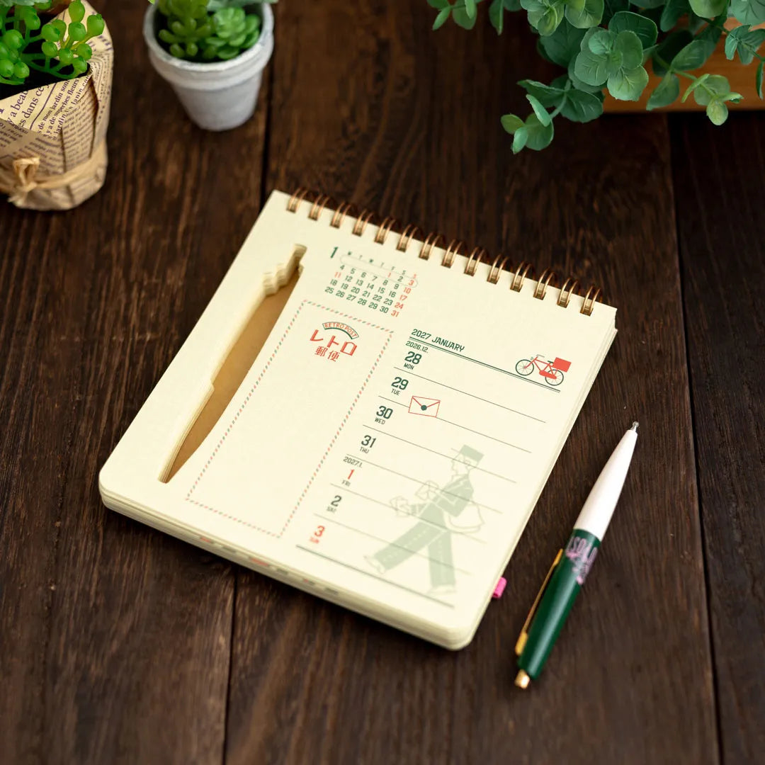 ob1toy Weekly Calendar 2027 open on a dark wooden table