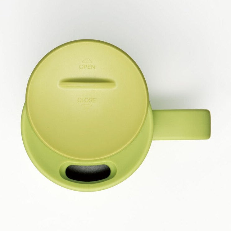 Close-up of light green Totoro mug lid showing OPEN CLOSE embossed text and drinking slot