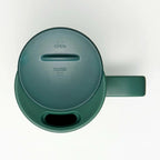 Top-down view of dark green travel mug lid with open and close indicators