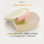 Beige plastic bento box with pink latch mechanism open to reveal white interior divider