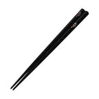 Diagonal view of sparkling black chopsticks with floral accents