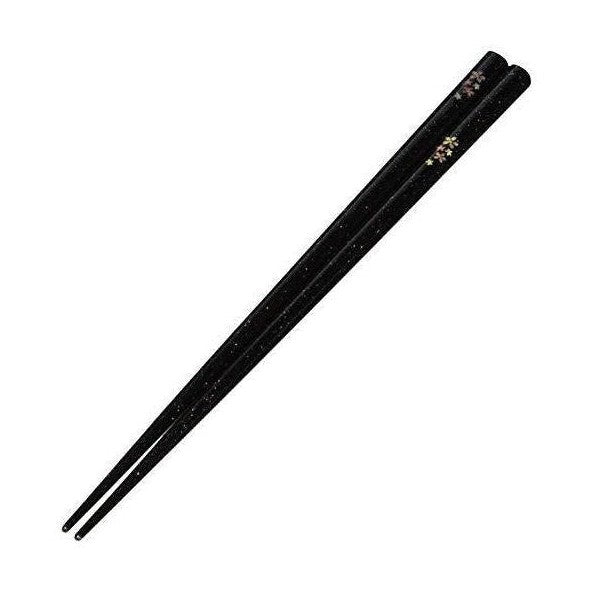Diagonal view of sparkling black chopsticks with floral accents