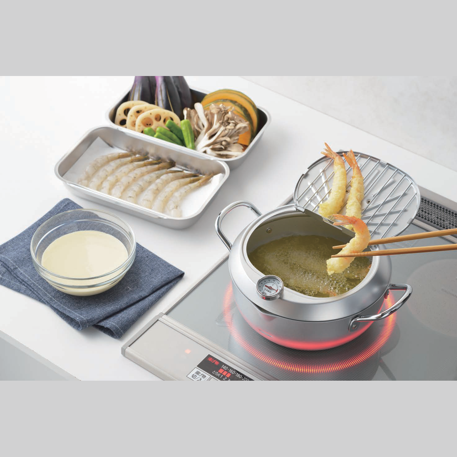 Yoshikawa stainless steel tempura pot with lid thermometer and drip tray cooking shrimp on induction cooktop