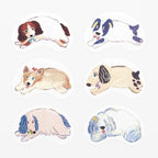 Assorted hand-drawn sleeping dog die-cut stickers in spaniel, corgi, and poodle designs