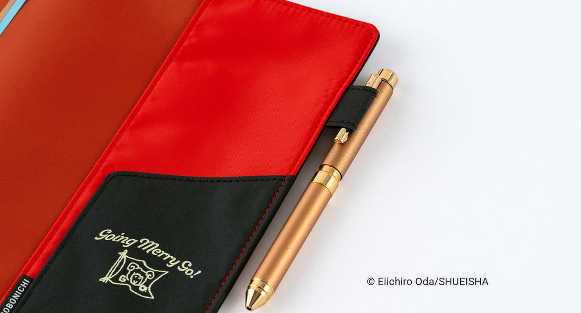 Hobonichi Techo A5 Cousins ONE PIECE magazine Going Merry Go! planner cover open, showing the red interior and a brass Hobonichi pen in the pen holder