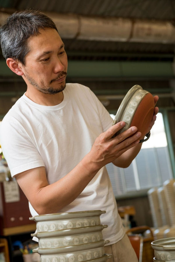 A Ginpo craftsman checking a donabe lid in the workshop