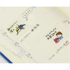 Open Hobonichi Techo planner decorated with colorful cartoon stickers for daily use
