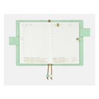 Open Hobonichi Techo A6 planner spread displaying grid-lined daily layout pages with Japanese text headers