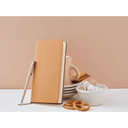 Tan Hobonichi Techo 2023 compact diary standing upright with matching pen