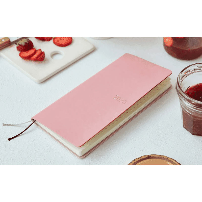 Pink Hobonichi Techo 2023 weekly planner with gold embossed year and ribbon bookmark
