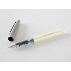 Midori fountain pen disassembled showing cream grip, transparent barrel, and silver cap with exposed nib
