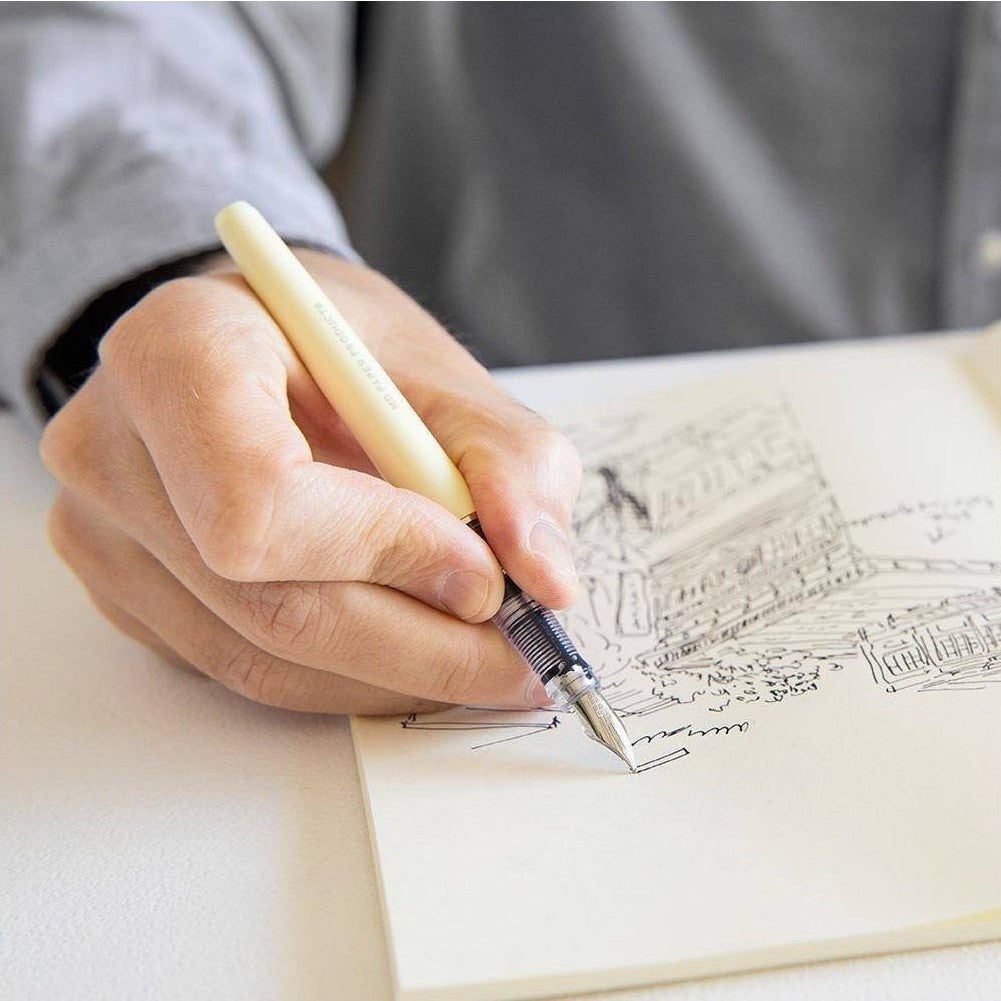 Hand writing with Midori fountain pen on notebook sketch using cream grip and metal nib