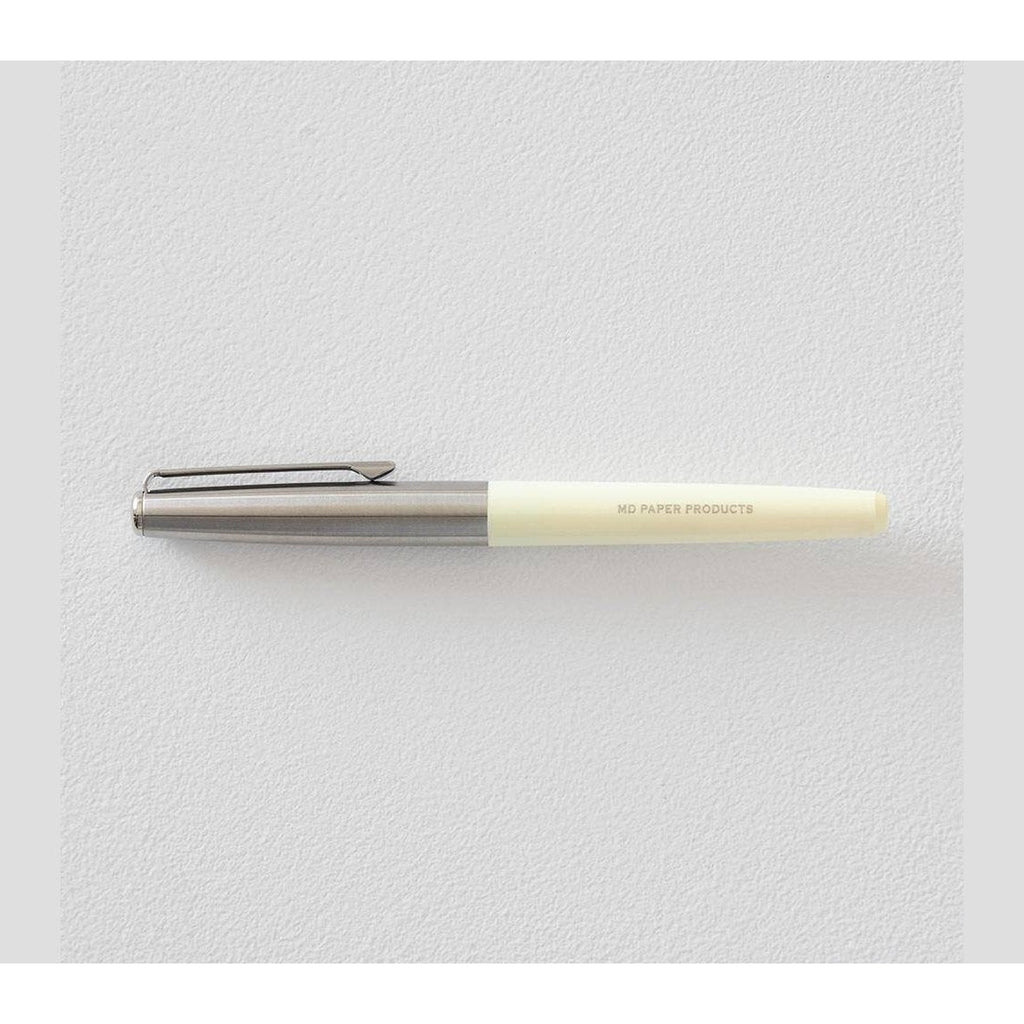 Assembled Midori fountain pen with brushed silver body, cream grip, and parallel silver cap on white surface