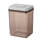 Brown translucent plastic food storage container with white snap-on lid and square base