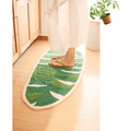 Tomo Banana Leaf mat in green and white on wooden floor with flip-flops