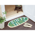 Tomo banana leaf mat S placed on wooden floor near doorway with slippers